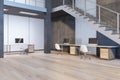 Side view on loft style spacious office with grey stairs on second floor, wooden floor and comfortable workspaces with modern Royalty Free Stock Photo