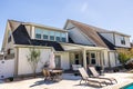 The side view of a long craftsman cottage white cream new construction house with a covered patio area