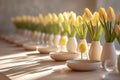 A side view of a long Easter dining table with a row of small vases, each holding a single yellow tulip.