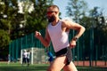 Side view of a male athlete sprinting on a running track in a track and field stadium holding a baton. Male runner Royalty Free Stock Photo