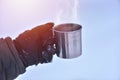 Side view of male hand in gloves holding cup with hot tea or coffee. Tea break. Winter time concept Royalty Free Stock Photo