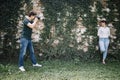 Side view of male photographer shooting woman in front of stone wall Royalty Free Stock Photo