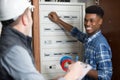 Side view male technician examining fusebox with multimeter probe Royalty Free Stock Photo