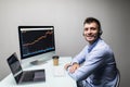 Side view of male trader with coffee cup using multiple computer screens while communicating through headphones at desk Royalty Free Stock Photo