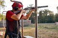 side view on man aiming with hunting rifle in the outer wood. Carbine with optical-sight. Royalty Free Stock Photo