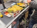 Side view of man arranging multiple food sweets vegetable fruits preserves on