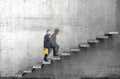 Side view of a man climbing up the steps in a blank concrete wall. 3d render Royalty Free Stock Photo