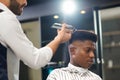 Side view of man getting trendy haircut in barber shop