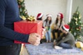 Man holding red gift box to surprise at the party with friends in New Year or Christmas concept Royalty Free Stock Photo