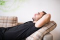Side view Man lying and relaxing on the couch at home in the living room Royalty Free Stock Photo