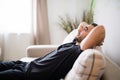 Side view Man lying and relaxing on the couch at home in the living room Royalty Free Stock Photo