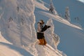 side view of man and with photo camera among snow-covered fir trees on mountain slope. Royalty Free Stock Photo