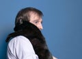 Man in shirt and holding and holding black cute cat on sholder on blue background