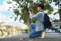 Side view of man traveller with backpack taking photo with digital camera near canal with beautiful sky on background Royalty Free Stock Photo