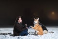 Side view at a man with two dogs at night in winter