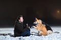 Side view at a man with two dogs at night in winter