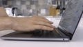 Side view of a man using laptop and typing on keyboard. Action. Close up of male hands typing a letter while working at Royalty Free Stock Photo