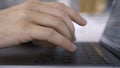 Side view of a man using laptop and typing on keyboard. Action. Close up of male hands typing a letter while working at Royalty Free Stock Photo