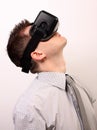 Side view of a man wearing a VR Virtual reality Oculus Rift 3D headset, exploring, looking very high upwards, wearing a shirt