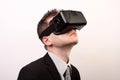 Side view of a man wearing a VR Virtual reality Oculus Rift 3D headset, looking upwards in a black official suit