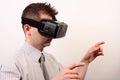 Side view of a man wearing a VR Virtual reality Oculus Rift 3D headset, touching or pointing at something with his hands Royalty Free Stock Photo