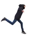 Side view of a man in a winter jacket who jumps