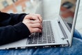 Side view of man& x27;s hands typing on laptop computer outdoors. Royalty Free Stock Photo