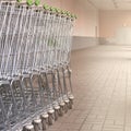 Side view of many metal shopping carts standing in a row on the street