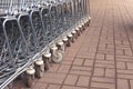 Side view of many metal shopping carts standing in a row on the street Royalty Free Stock Photo