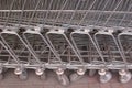 Side view of many metal shopping carts standing in a row on the street Royalty Free Stock Photo