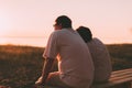 Side view a married couple a silhouette sitting on a bench. Royalty Free Stock Photo