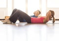 Side View Of Mature Couple Practicing Sit-Ups At Home