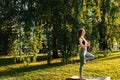 Side view of meditative young woman with closed eyes standing in the pose of Vrikshasana tree