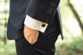 Side view of men in black suit. Close up of hand in pocket. Black square cufflinks on white shirt sleeves. Outdoor Royalty Free Stock Photo