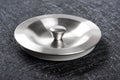 Metal sink plug on dark background