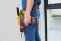 Side view mid section of a handyman with drill and toolbelt Royalty Free Stock Photo
