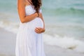 Side view midsection of a pregnant woman touching tummy against ocean Royalty Free Stock Photo