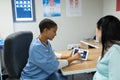 Female doctor discussing baby ultrasound report on digital tablet with pregnant woman at hospital Royalty Free Stock Photo