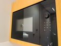 Side view of modern Bosch microwave oven with black glass and white buttons