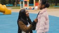 Side view mom laugh with daughter in playground cute little girl tell funny story mother smiling listening to kid child