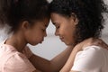 Side view mother and daughter touches foreheads moment of tenderness