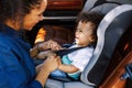 Side view of a mother helping toddler get buckled