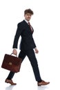 Side view of motivated businessman holding his briefcase