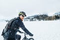 Side view of mountain biker riding in snow outdoors in winter nature. Royalty Free Stock Photo