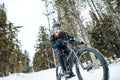 Side view of mountain biker riding in snow outdoors in winter nature. Royalty Free Stock Photo