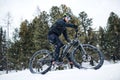 Side view of mountain biker riding in snow outdoors in winter nature. Royalty Free Stock Photo