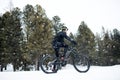 Side view of mountain biker riding in snow outdoors in winter nature. Royalty Free Stock Photo