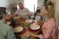Family praying together before having meal on dining table Royalty Free Stock Photo