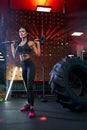 Fit woman posing with sledgehammer in gym. Royalty Free Stock Photo