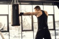 side view of muscular young boxer training with punching bag Royalty Free Stock Photo